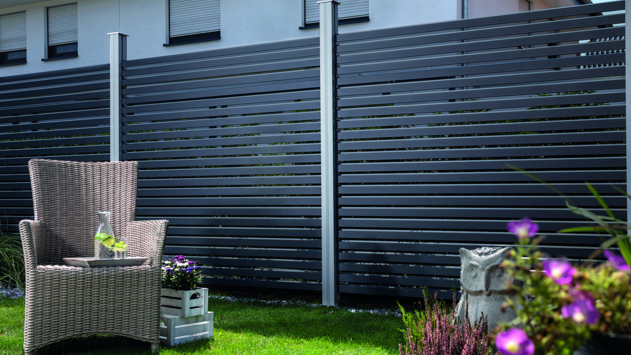 Moderner Alu-Rhombus-Sichtschutzzaun in Anthrazit mit stilvollem Gartenambiente und Loungesessel.